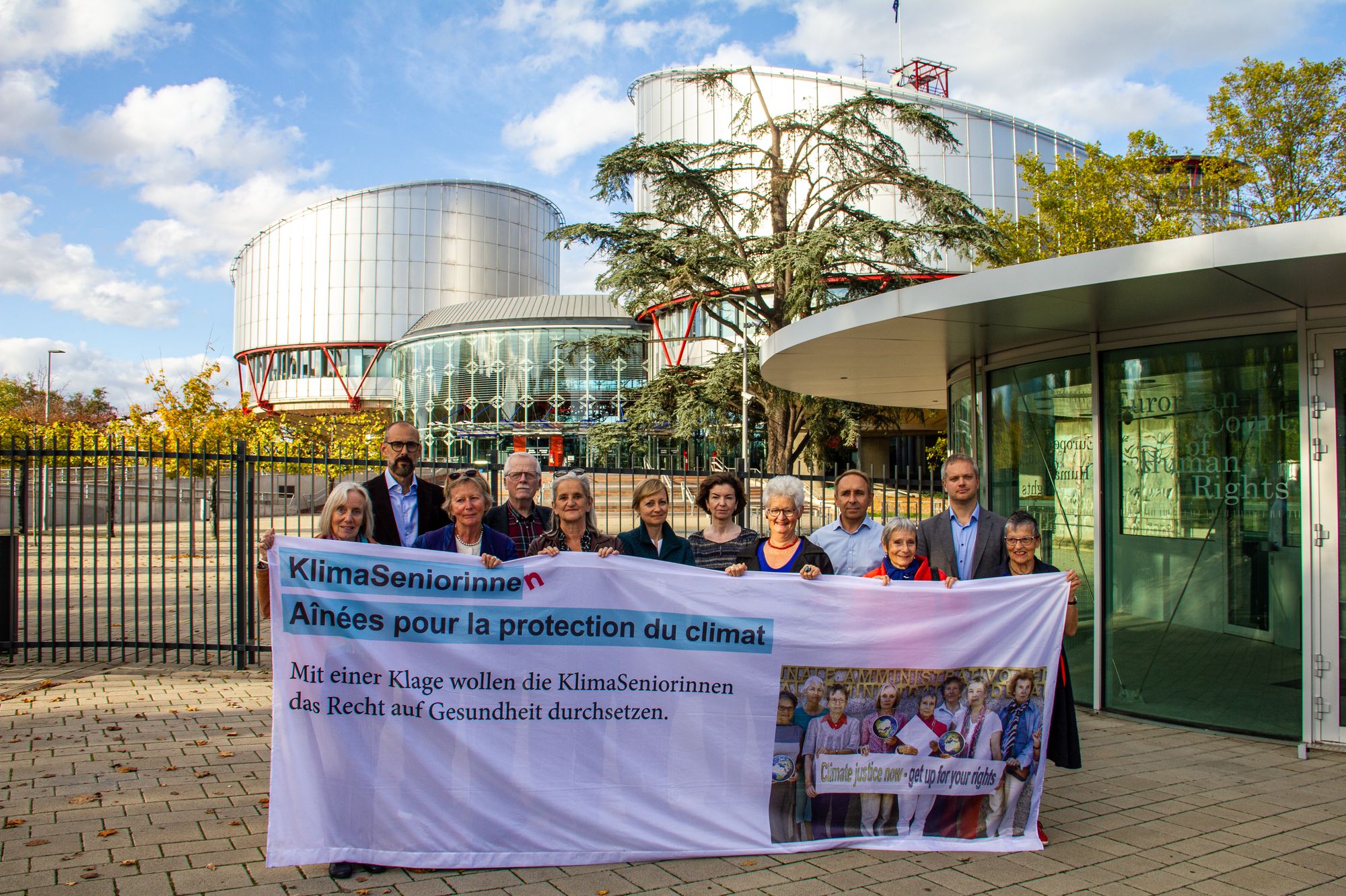 KlimaSeniorinnen, a group of older Swiss women, hold a banner about climate change in front of the European Court of Human Rights
